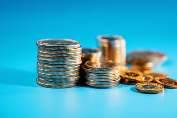 Swiss coins are stacked on a blue background. Background for your design.