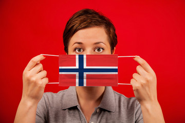 Coronavirus COVID-19 in Norway. Woman in medical protective mask with the image of the flag of Norway.