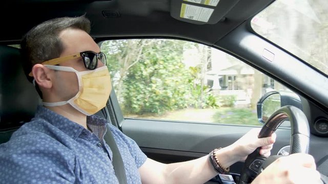 408 Man driving wearing a face mask and sunglasses Covid-19