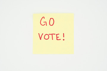 Go vote! written on a yellow sticky note with copyspace. Presidential election 2020