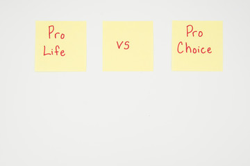 Pro life versus Pro Choice written on a yellow sticky note with copyspace. Presidential election 2020