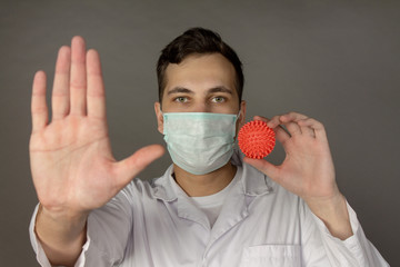 Portrait of a doctor in a medical gown clutching his head because of the number of patients with coronavirus.