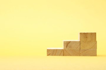 黄色背景に三段に積み上げられた積み木 01