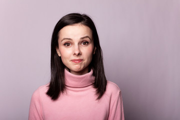 beautiful girl in a pink turtleneck on a gray background