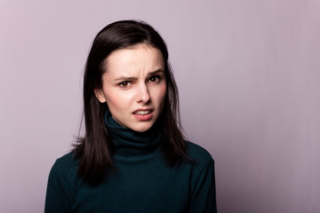 Obraz premium beautiful girl in a green turtleneck on a gray photo