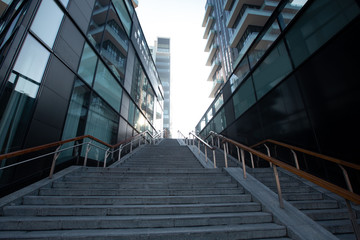 A staircase in a big city leading to multi-storey modern houses. 01.20 Milan