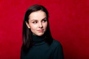 girl in a green turtleneck, portrait on a red background