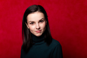 girl in a green turtleneck, portrait on a red background