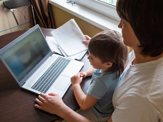 Self-isolation because of coronavirus outbreak. Man is remote working with his little son on self quarantine. Lockdown indoors.