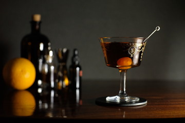 Manhattan red delitious cocktail with orange on dark background