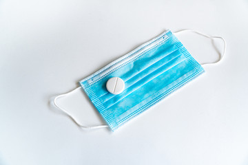 Coronavirus vaccine COVID-19. Rubber medical mask with a tablet. Coronavirus tablet. Disposable items of protective equipment from coronavirus on a white background.