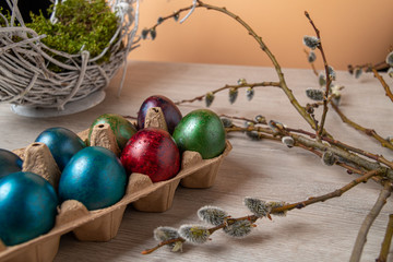 Colorful easter eggs in an egg palette and on an old wooden table. Easter concept.