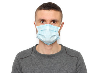 Portrait of brunette man in a surgical bandage on a  white background, coronavirus, illness, infection, quarantine, medical mask