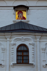 Fototapeta premium Fragment of the facade of a white stone Orthodox church with a window and an icon