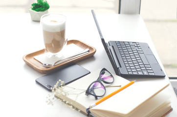 A table in a bright cafe with latte and freelancer work details.