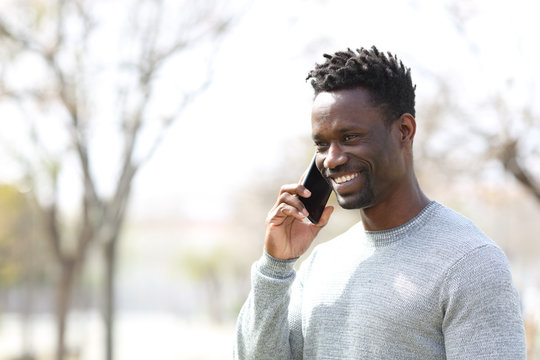 Happy Black Man Talking On Smart Phone In A Park