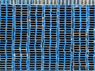 Fototapeta na wymiar Large stacks of blue wooden pallets