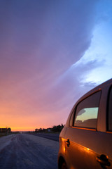 Fototapeta na wymiar Car on a road at sunset