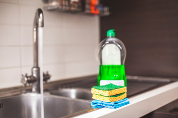 Sponges to clean in the foreground and detergent.