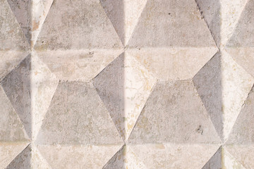 concrete fence in the form of a pyramid, painted in beige color, closeup of construction details. stone background and texture