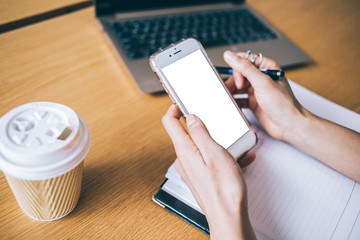 Crop woman using smartphone at table