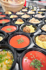 Food delivery. Different in plastic disposable lunch box with healthy natural food. Chicken broth, mashed soup, mashed potatoes with cutlet, seafood pasta, salads, pilaf with a fresh bun.