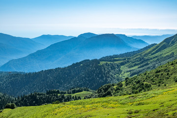Obraz premium View over the Green Valley, surrounded by high mountains on a clear summer day