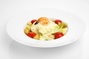 Salad with fresh vegetables and shrimp on a white plate