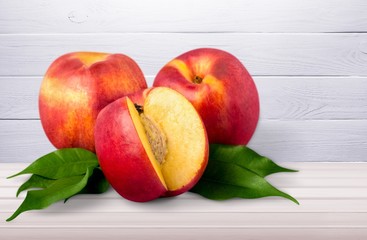 Fresh ripe whole and cut tasty peach fruit on the desk