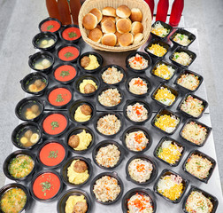 Row of plastic disposable lunch box with healthy natural food. Soups, cream soup, main course with side dish, salads. Food delivery. Lunch in the office.