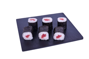Traditional fresh japanese sushi maki on black stone Maki Theca on a white background. Roll ingredients: Tuna, nori, rice.
