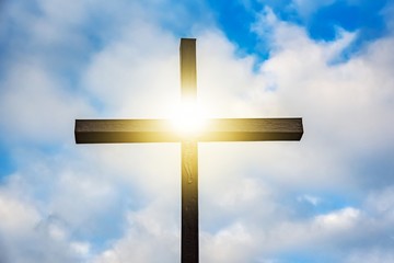 Wooden cross against sky background   , Easter background. Christian cross against celestial clouds. 