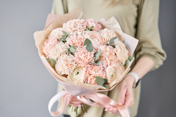 Small flower shop and Flowers delivery. Beautiful bouquet of mixed flowers in woman hands. Work of the florist at a flower shop. Delivery fresh cut flower.
