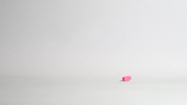 Pills and medicines falling in slow motion on white background. Cure and treatment against viruses and bacteria. Vitamin complex. Slow motion. Macro shot, detail.
