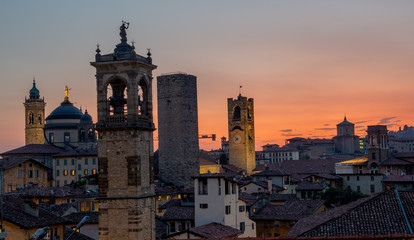 Bergamo at sunset in the old city with towers and bell tower,