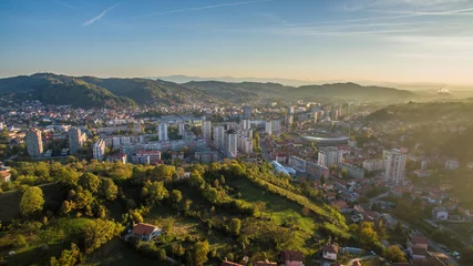 Poster Aerial view of downtown Tuzla at sunset, Bosnia. City photographed by drone, traffic and objects , landscape.Tuzla city photographed by drone from air. Buildings near park. Old balkan city with large  © adis97
