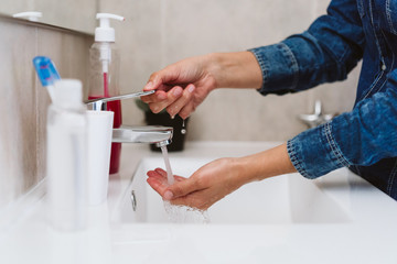 unrecognizable woman washing hands on a sink with soap. Coronavirus covid-19 concept