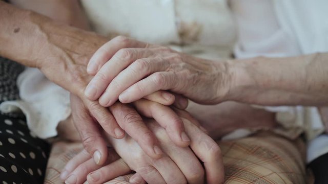Close view of putting old female hands on hands together of three grandmothers