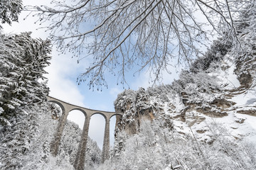 Het Landwasser-viaduct met spoorweg zonder beroemde trein in de winter, oriëntatiepunt van Zwitserland, sneeuwt, rivier en bergen