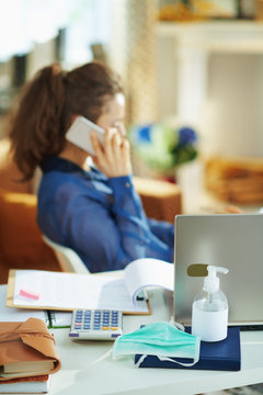 medical mask and hand disinfectant and woman talking on phone