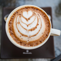 A bird's eye view of white coffee with cocoa , white coffee with black background, coffee served in cafe, morning cappuccino, macchiato in a professional way