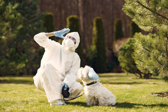 Woman In A Protective Suit. Person In A Mask. Woman With A Dog.