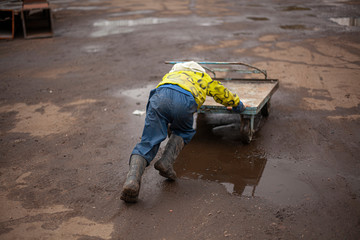 A child plays with a cart on the street.