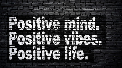 Positive mind, positive vibes, positive life, motivation slogan, white text on black brick wall