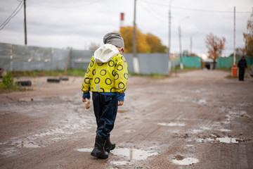 Fototapeta premium The child runs through the puddles.