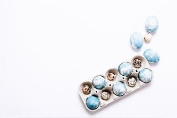 Stylish background of Easter eggs in cardboard egg case on white background, copy space