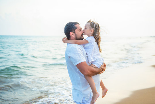 Gentle hugs and a kiss on the sea. Loving father and daughter on the sea coast, happy family