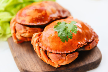 Fresh seafood stone crab - Crab cooked steam or boiled with salad vegetable on wooden board on white background