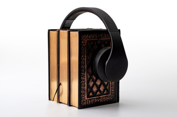 Learning and studying, listen to audiobook and digital media library concept with stack of hardcover books and over the head headphone isolate on white background with clipping path included