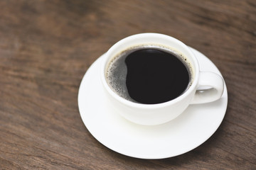 Coffee cup on table - black coffee in white mug on wooden background